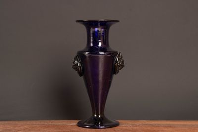 a purple vase sitting on top of a wooden table