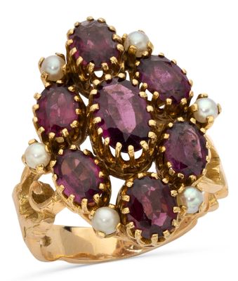 a close up of a gold ring with purple stones and pearls