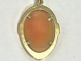 gold plated pendant with a red stone in the middle of it