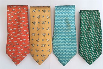 four ties are lined up in a row on a white surface
