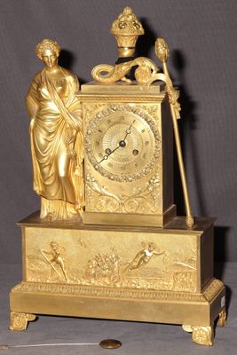 une horloge en or surmontée d'une statue