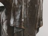 bronze statue of a woman reading a book on a marble base
