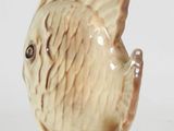 a ceramic fish figurine sitting on a white surface