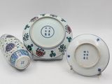 three vases and a bowl sitting on a white surface