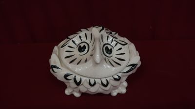 un hibou en céramique posé sur une surface rouge