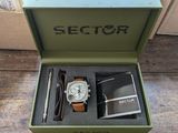une boîte contenant une montre et un stylo, posée sur une table