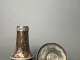 pair of antique brass vases and a plate on a gray background