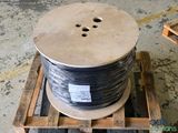 a spool of black wire on a wooden pallet