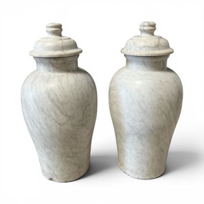 deux vases blancs posés l'un à côté de l'autre sur une surface blanche