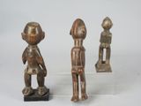 three wooden figurines of a boy and a girl on a clear base