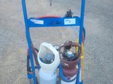 un chariot bleu sur lequel se trouvent deux bouteilles de gaz et un tuyau