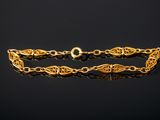 a close up of a gold bracelet on a black surface