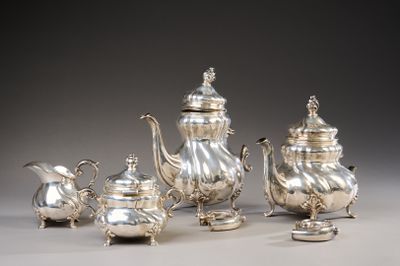 silver plated tea and coffee set on stand on grey background