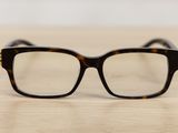 glasses on a wooden table with a white wall in the background