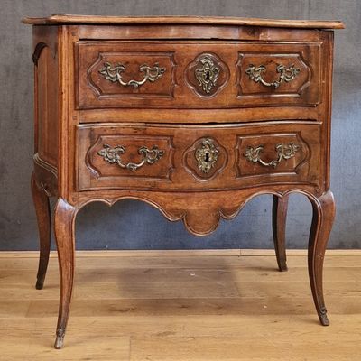 a small wooden chest of drawers on a wooden floor
