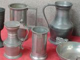 beaucoup d'objets en étain posés sur une table rouge