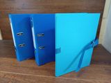 two blue binders are sitting on a wooden table