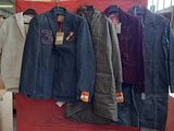de nombreuses vestes suspendues à un portant dans un magasin
