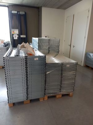 de nombreuses piles de tôles empilées sur des palettes dans une pièce