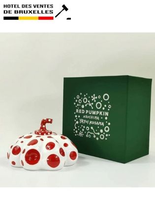 a red and white polka dot covered jar next to a green box