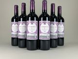 six bottles of wine are lined up on a table