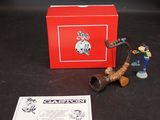 une boîte rouge sur laquelle sont représentés une pipe et quelques figurines