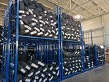 a lot of tires stacked on a rack in a warehouse