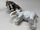 two figurines of elephants sitting next to each other on a table