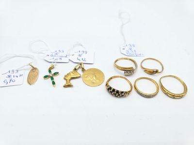 plusieurs bagues en or et d'autres bijoux posés sur une surface blanche