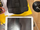 une tablette posée sur une table, à côté d'un ordinateur portable