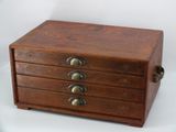 a small wooden box with five drawers on it