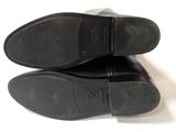 the bottom of a pair of men ' s black shoes on a white surface
