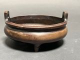a small metal bowl with a handle on a table