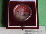 une pièce d'argent dans une boîte rouge posée sur une surface verte