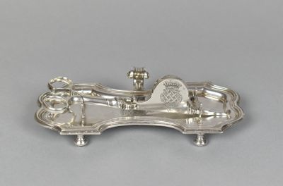 une assiette en argent ancien sur laquelle est représenté un cheval et une calèche
