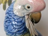 a figurine of a colorful parrot on a white background