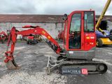 a red excavator that is parked in a parking lot