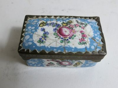 une boîte bleue et blanche ornée d'une rose rose