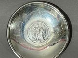 an image of a silver plate with a picture of a man and a woman on it
