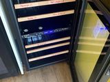 an image of a wine cooler in the corner of a kitchen
