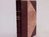 an old book sitting on top of a white table next to a white wall