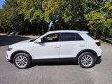 a white volkswagen suv parked on the side of the road