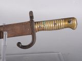 a gold colored sword on display in a glass case