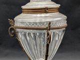 an antique silver and glass urn with a bird on top of it