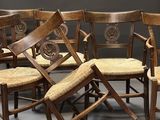 Six chaises en bois sont alignées en cercle sur un sol gris.