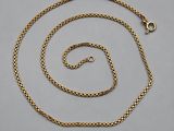 a gold plated chain with a clasp on a gray background