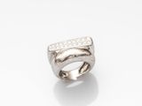 a close up of a ring with diamonds on a white surface