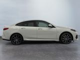 the white car is parked on the concrete floor in the room