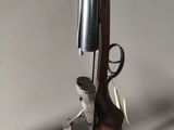 a gun with a wooden handle and a metal handle on a stand