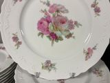 a stack of white plates with pink flowers on them